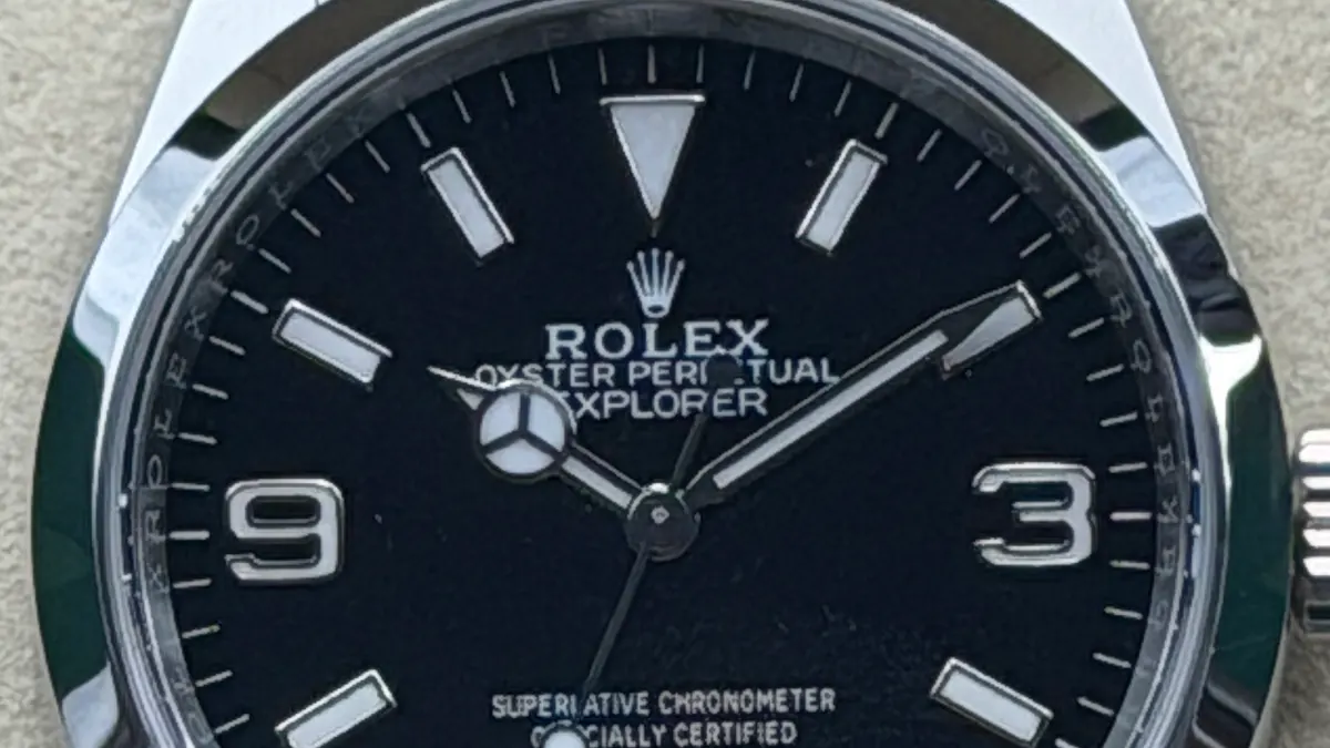 Makroaufnahme des Zifferblatts einer Rolex Explorer 36 (Ref. 124270) aus unserem Bestand: Typografie, Indexe und Zeiger sowie die Verarbeitung von Rehaut und Gehäuse